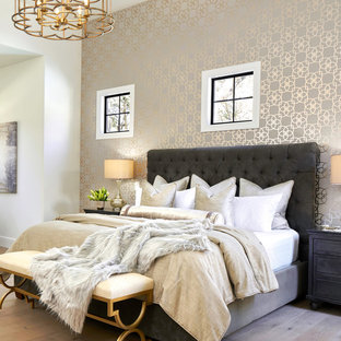 Cette image montre une très grand chambre parentale traditionnelle avec un mur blanc et un sol en bois clair.