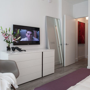 Example of a mid-sized minimalist guest ceramic tile bedroom design in Miami with white walls and no fireplace