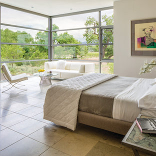 Modelo de dormitorio contemporáneo, grande, con suelo de travertino y paredes beige