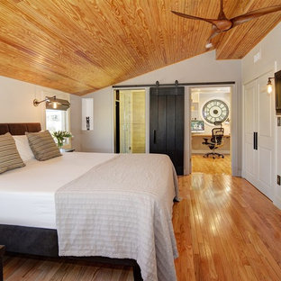 Modelo de dormitorio principal, clásico renovado, extra grande, con paredes grises y suelo de madera en tonos medios