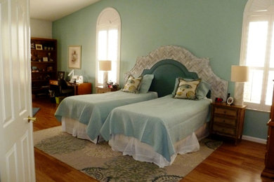 Modelo de dormitorio principal costero grande con paredes multicolor y suelo de madera clara