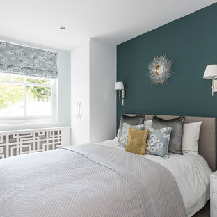Design ideas for a medium sized world-inspired bedroom in London with blue walls, carpet and beige floors.