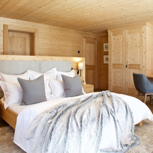 Design ideas for a large rustic master bedroom in London with beige walls, medium hardwood flooring and brown floors.