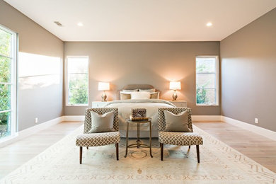 Imagen de dormitorio principal clásico renovado grande sin chimenea con paredes grises y suelo de madera clara