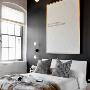 Immagine di una camera da letto contemporanea con pareti nere e pavimento in legno massello medio
