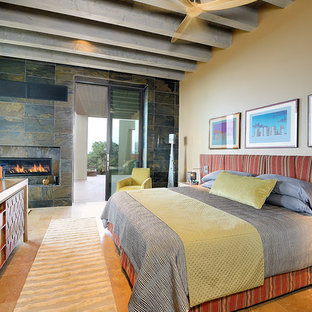 Foto de dormitorio principal, clásico renovado, grande, con paredes beige, suelo de piedra caliza, chimenea lineal, marco de chimenea de baldosas y/o azulejos y suelo beige