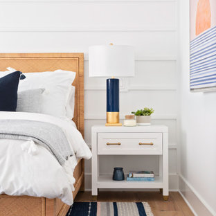 Mittelgroßes Maritimes Schlafzimmer mit weißer Wandfarbe, braunem Holzboden, beigem Boden und Holzdielenwänden in Tampa