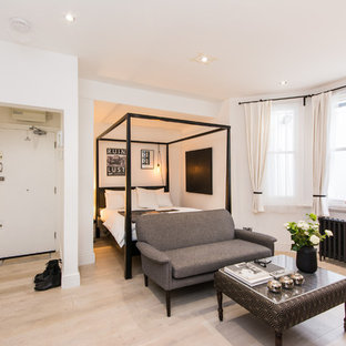 Inspiration for a small traditional bedroom in London with light hardwood flooring, white walls and beige floors.