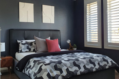 Imagen de dormitorio contemporáneo pequeño con paredes grises, suelo laminado y suelo gris
