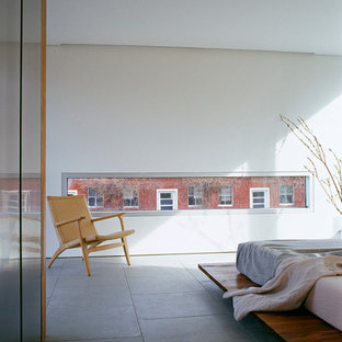 Diseño de dormitorio actual con paredes blancas, suelo de piedra caliza y suelo gris