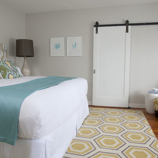 Transitional medium tone wood floor bedroom photo in Providence with gray walls