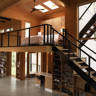 Diseño de dormitorio tipo loft, actual, de tamaño medio, sin chimenea, con paredes marrones, suelo de madera en tonos medios y suelo marrón