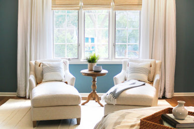 Ejemplo de dormitorio principal clásico grande con paredes azules y suelo de madera clara