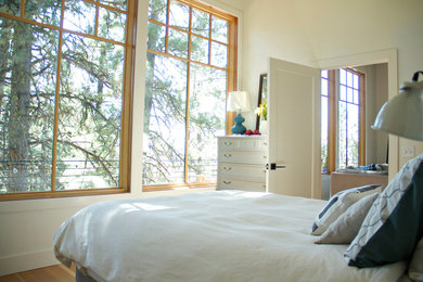 Modelo de habitación de invitados minimalista de tamaño medio sin chimenea con suelo de madera clara, paredes blancas y suelo marrón
