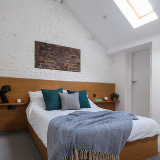 Mittelgroßes Modernes Hauptschlafzimmer mit weißer Wandfarbe, Teppichboden, grauem Boden, gewölbter Decke und Ziegelwänden in West Midlands
