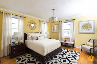 Foto de dormitorio principal clásico renovado grande sin chimenea con paredes amarillas y suelo de madera clara