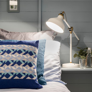 Foto de habitación de invitados nórdica, pequeña, con paredes azules, suelo laminado, estufa de leña y suelo gris