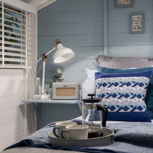 Imagen de habitación de invitados nórdica, pequeña, con paredes azules, suelo laminado, estufa de leña y suelo gris