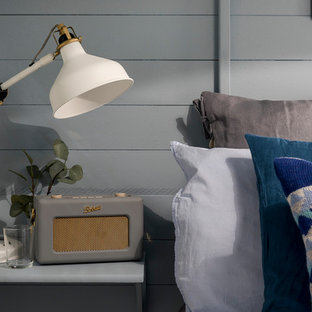 Foto de habitación de invitados nórdica, pequeña, con paredes azules, suelo laminado, estufa de leña y suelo gris