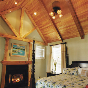 Imagen de dormitorio principal, rústico, extra grande, con paredes verdes, moqueta, chimenea tradicional y marco de chimenea de madera