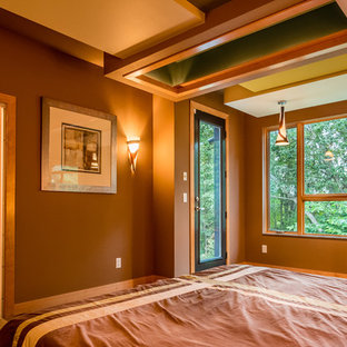Foto de dormitorio principal, contemporáneo, grande, con paredes multicolor, suelo de madera clara, chimenea de doble cara, marco de chimenea de madera y suelo marrón