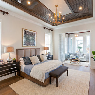 Ejemplo de dormitorio principal, tropical, extra grande, con paredes beige, suelo de madera en tonos medios y suelo marrón