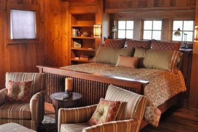 Ejemplo de dormitorio principal rural de tamaño medio sin chimenea con paredes marrones y suelo de madera oscura