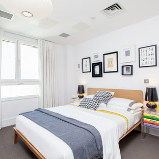 Photo of a contemporary bedroom in London with white walls and carpet.