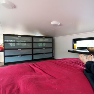 Foto de dormitorio tipo loft, moderno, pequeño, con paredes blancas y suelo de madera en tonos medios
