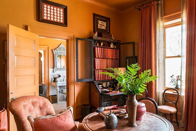 Elegant master bedroom photo in New York with orange walls