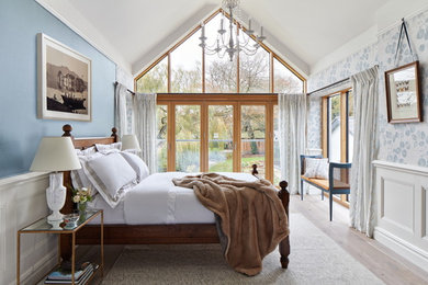 Ejemplo de dormitorio clásico con paredes azules, suelo de madera clara y suelo beige