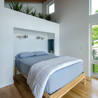 Imagen de dormitorio principal, contemporáneo, de tamaño medio, con paredes blancas, suelo de madera en tonos medios y suelo amarillo
