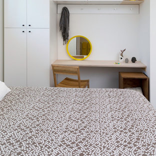 Imagen de dormitorio tipo loft, actual, pequeño, con paredes blancas, suelo de cemento y suelo negro