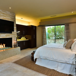Diseño de habitación de invitados contemporánea, grande, con paredes beige, suelo de travertino, chimenea tradicional y marco de chimenea de baldosas y/o azulejos