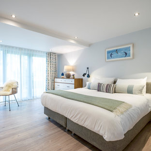 Photo of a large nautical master bedroom in Cornwall with grey walls, light hardwood flooring and beige floors.