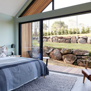 Inspiration for a beach style master bedroom in Other with green walls and medium hardwood floors.