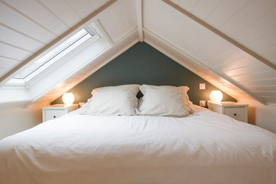 ロンドンにある小さなモダンスタイルのおしゃれなロフト寝室 (青い壁、カーペット敷き、ベージュの床) のインテリア