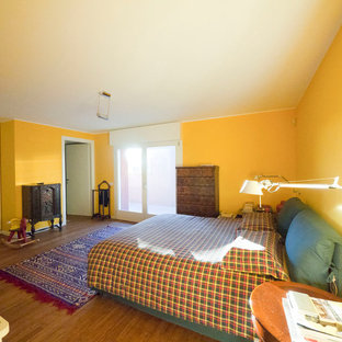 Imagen de dormitorio principal, ecléctico, grande, con paredes amarillas y suelo de bambú