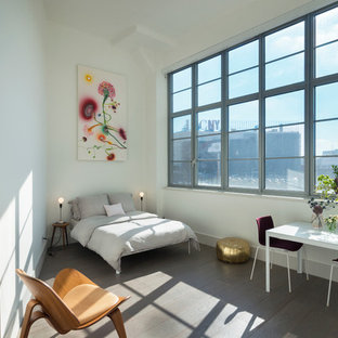 Modelo de dormitorio tipo loft, actual, sin chimenea, con paredes blancas y suelo de madera en tonos medios