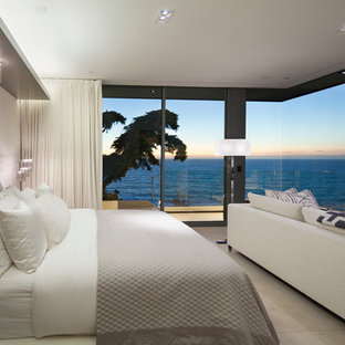 Mittelgroßes Modernes Hauptschlafzimmer mit beiger Wandfarbe, Kalkstein, Kamin und Kaminumrandung aus Stein in Orange County