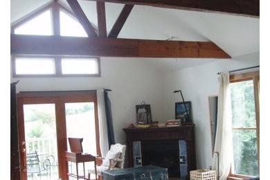 ナッシュビルにある広いカントリー風のおしゃれな主寝室 (白い壁、コーナー設置型暖炉、木材の暖炉まわり)