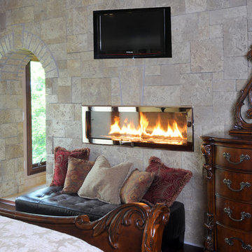 Tiled Wall in Master Bedroom Features Archway and Two Sided Fireplace