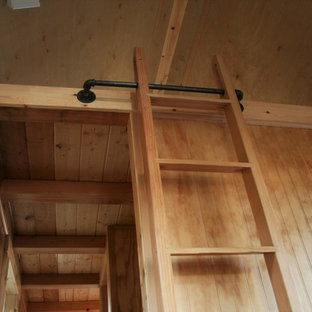 Foto de dormitorio tipo loft, rústico, pequeño, sin chimenea, con paredes marrones y suelo de madera oscura