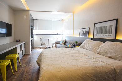 他の地域にある小さなコンテンポラリースタイルのおしゃれなロフト寝室 (グレーの壁、磁器タイルの床、茶色い床) のインテリア