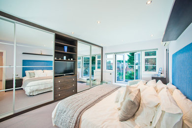 Photo of a large contemporary master bedroom in London.