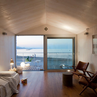 Scandinavian bedroom in Other with beige walls and medium hardwood floors.