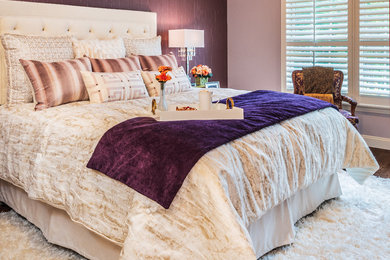 Ejemplo de dormitorio principal clásico de tamaño medio con paredes púrpuras y suelo de madera en tonos medios