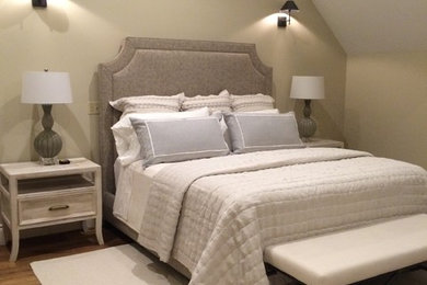 Imagen de dormitorio principal clásico grande con paredes beige, suelo de madera en tonos medios, marco de chimenea de piedra y suelo marrón