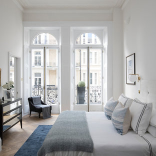 This is an example of a classic bedroom in London with white walls, medium hardwood flooring and brown floors.