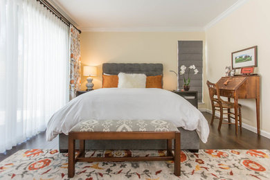 Modelo de habitación de invitados clásica de tamaño medio sin chimenea con paredes beige y suelo de madera oscura